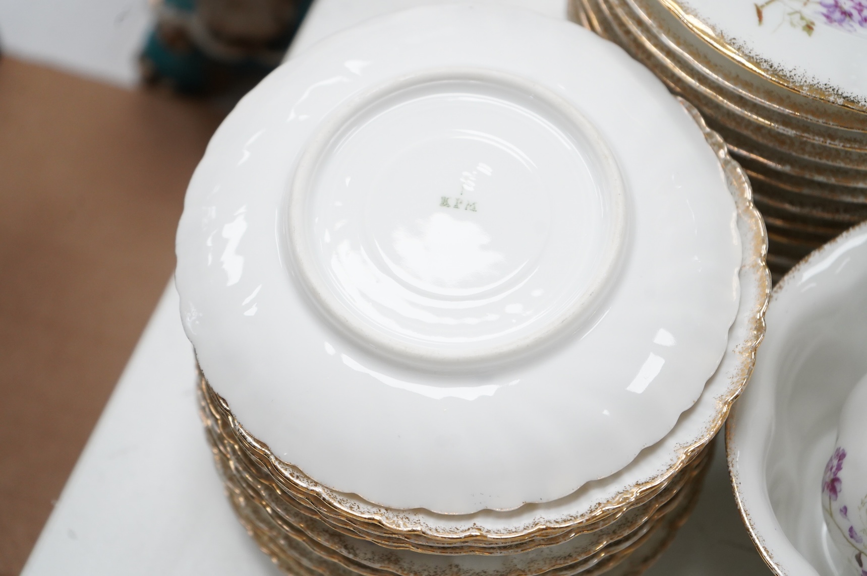 A KPM style floral porcelain part tea service, largest 27cm in diameter